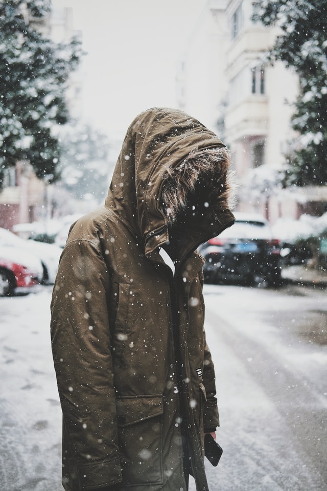 standing in the snowfall on a busy street